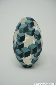 Dieses Bild zeigt die jurierte EmuEi-Skulptur " Würfelspiel ". Kuriert für GCC German Crafts Collection, Part of the Collection 2025 des Bundesverbandes Kunsthandwerk und Kunst Design. Die Ausstellung findet vom 22.11.25 bis 14.12.25 in der Handwerksform Hannover, Berliner Allee 15 in 30175 Hannover statt.